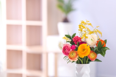 Photo of Vase with beautiful ranunculus flowers on blurred background