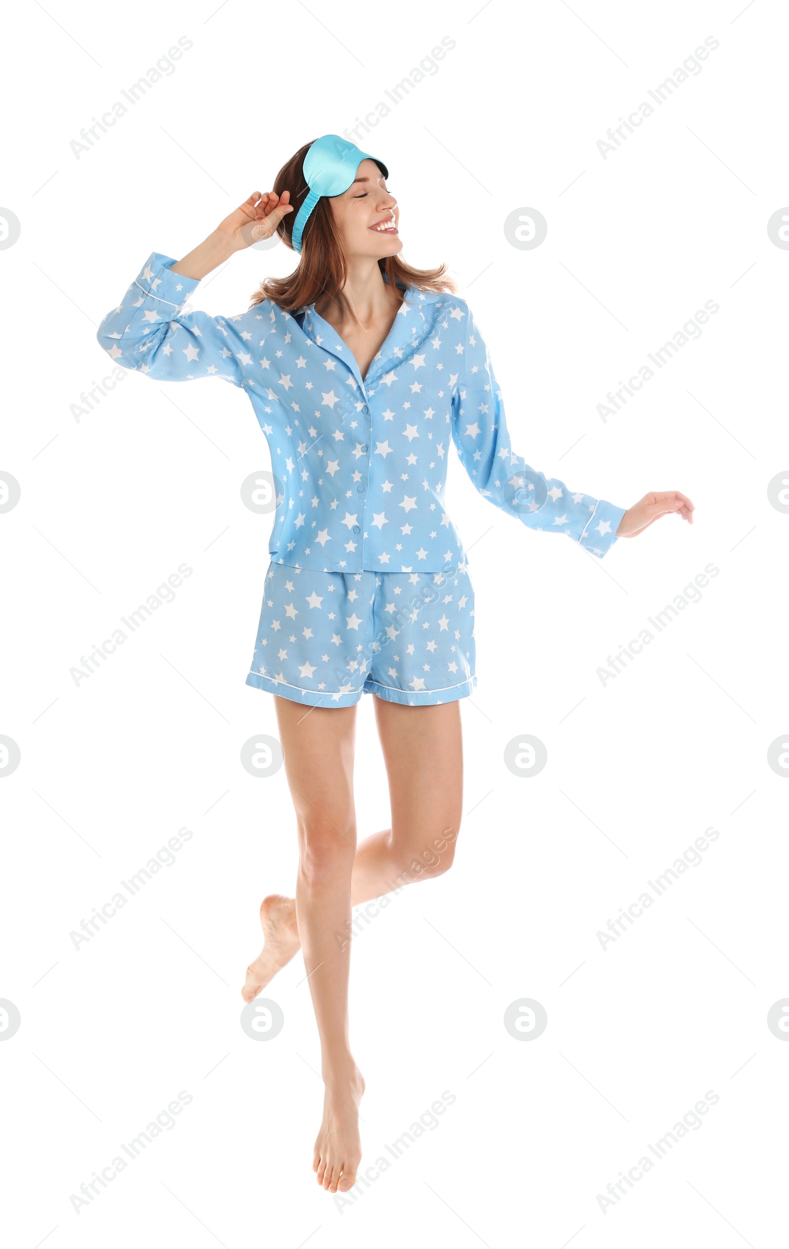 Photo of Beautiful woman with sleep mask jumping on white background. Bedtime