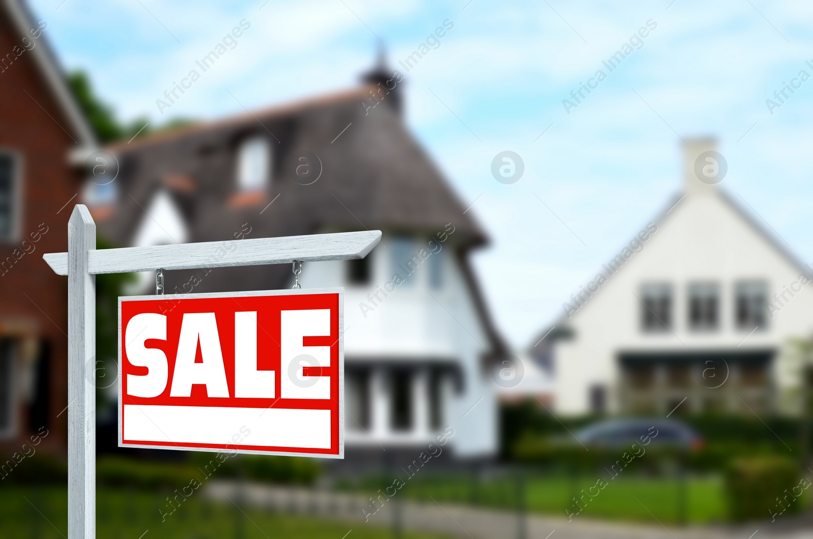 Image of Red Sale sign near new house outdoors. Space for text