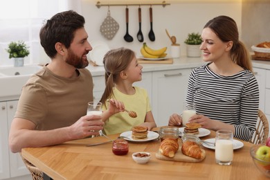 Happy family having breakfast at table in kitchen