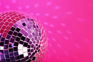 Photo of Shiny disco ball on pink background, closeup. Space for text