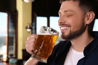 Bearded man drinking tasty beer in pub