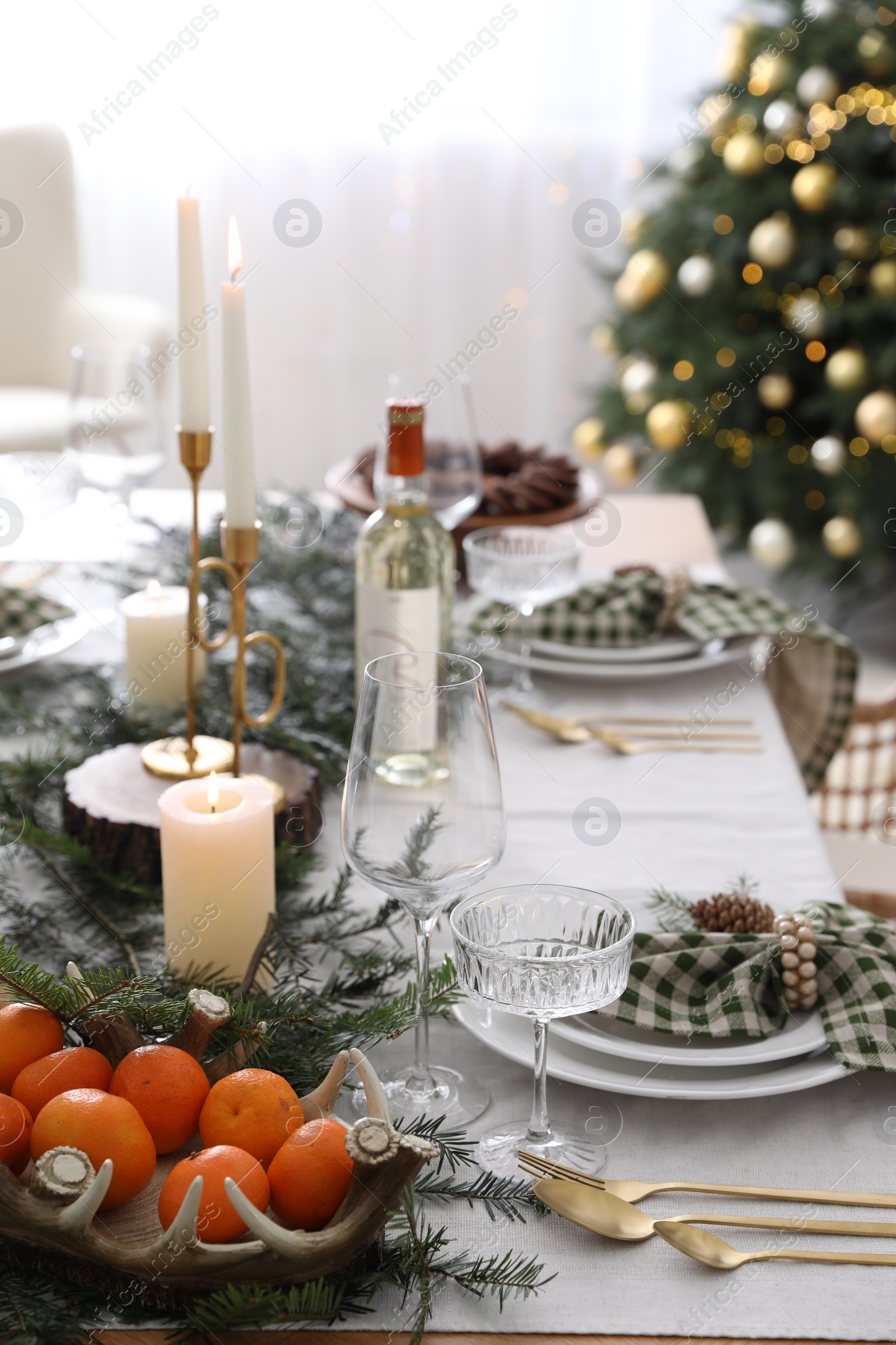 Photo of Christmas table setting with festive decor and dishware indoors