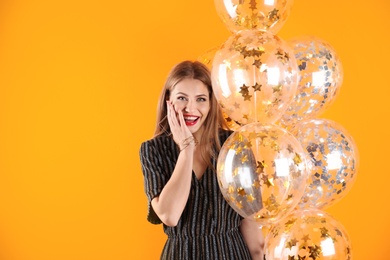 Photo of Young woman with air balloons on color background