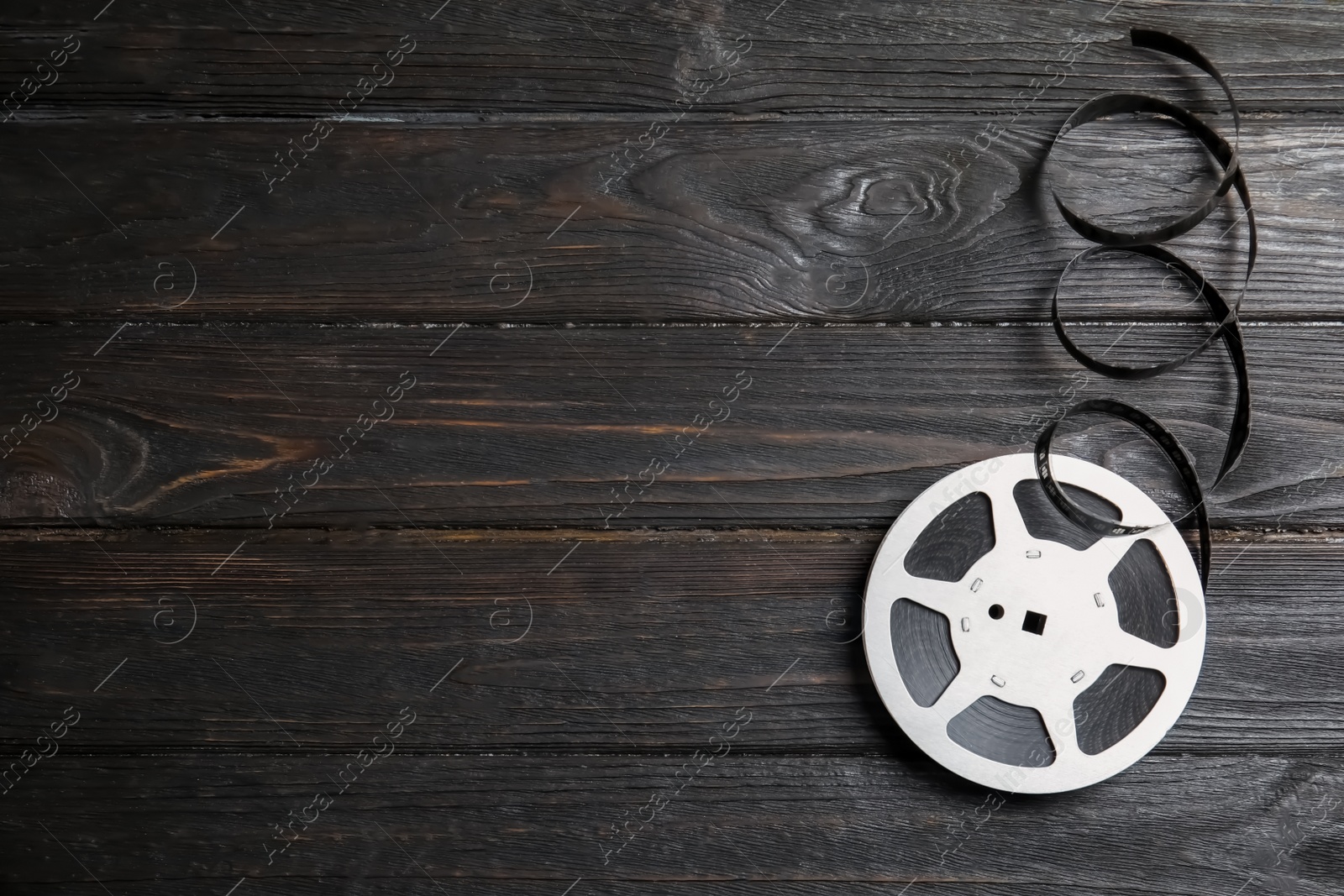 Photo of Movie reel on wooden background, top view with space for text. Cinema production