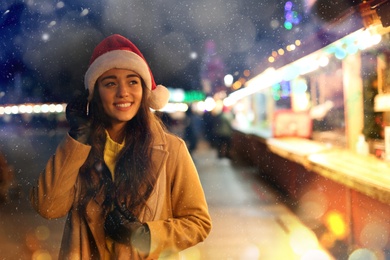 Image of Young woman spending time at Christmas fair, space for text