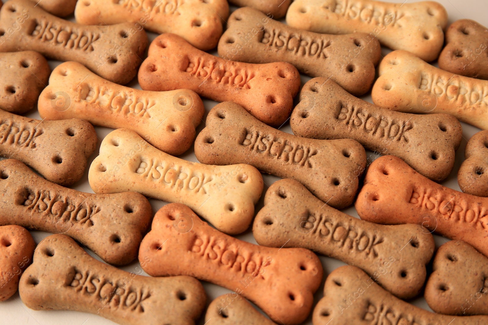 Photo of Bone shaped dog cookies on beige background