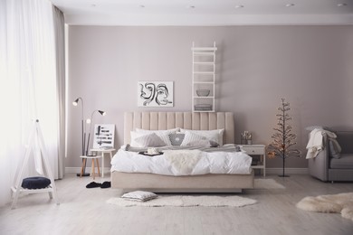 Photo of Cozy bedroom interior with decorative tree and beautiful pictures