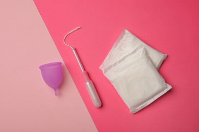 Menstrual cup, pads and tampon on color background, flat lay