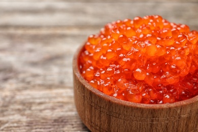 Photo of Bowl with delicious red caviar on table