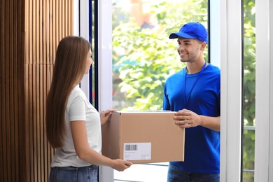 Photo of Woman receiving parcel from courier on doorstep