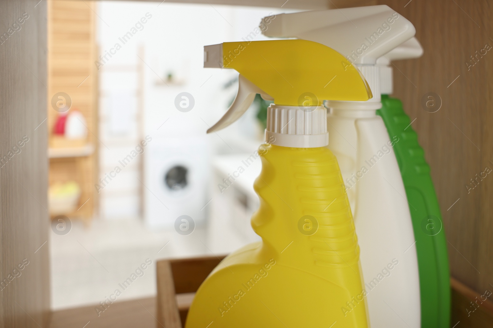 Photo of Spray detergents in laundry room, closeup. Space for text