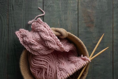 Photo of Soft pink woolen yarn, knitting and needles on wooden table, top view