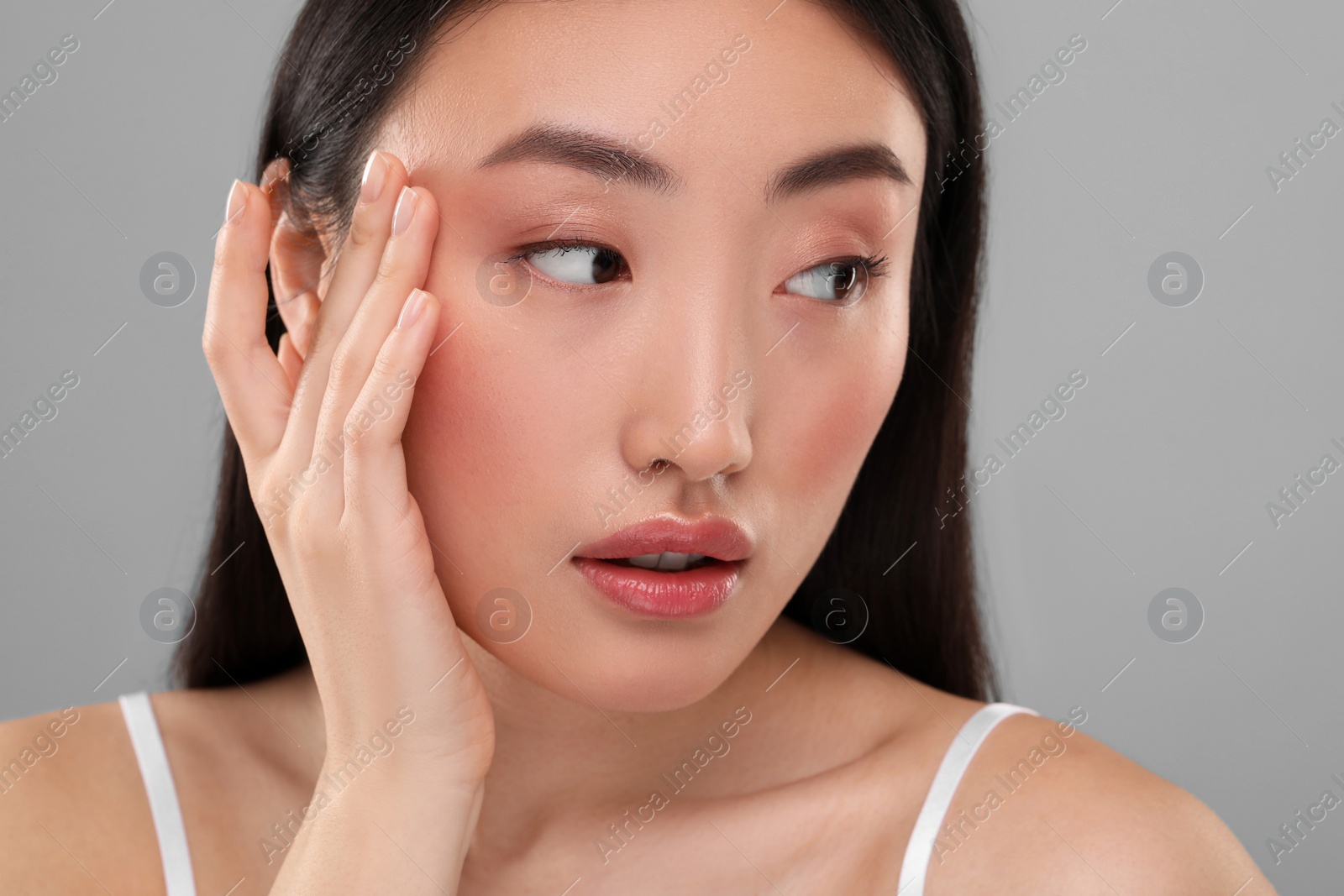 Photo of Beautiful woman with healthy skin on gray background, closeup