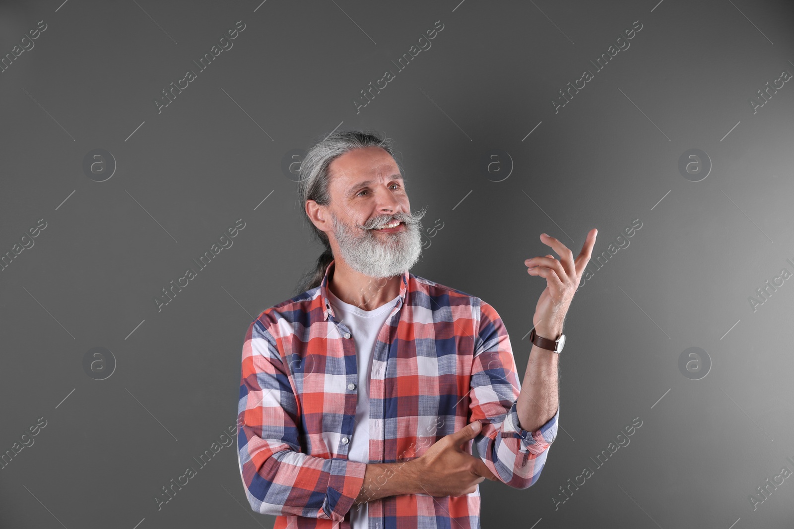 Photo of Handsome bearded mature man on color background