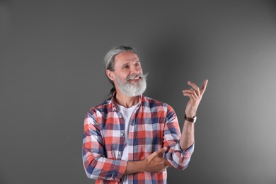 Handsome bearded mature man on color background