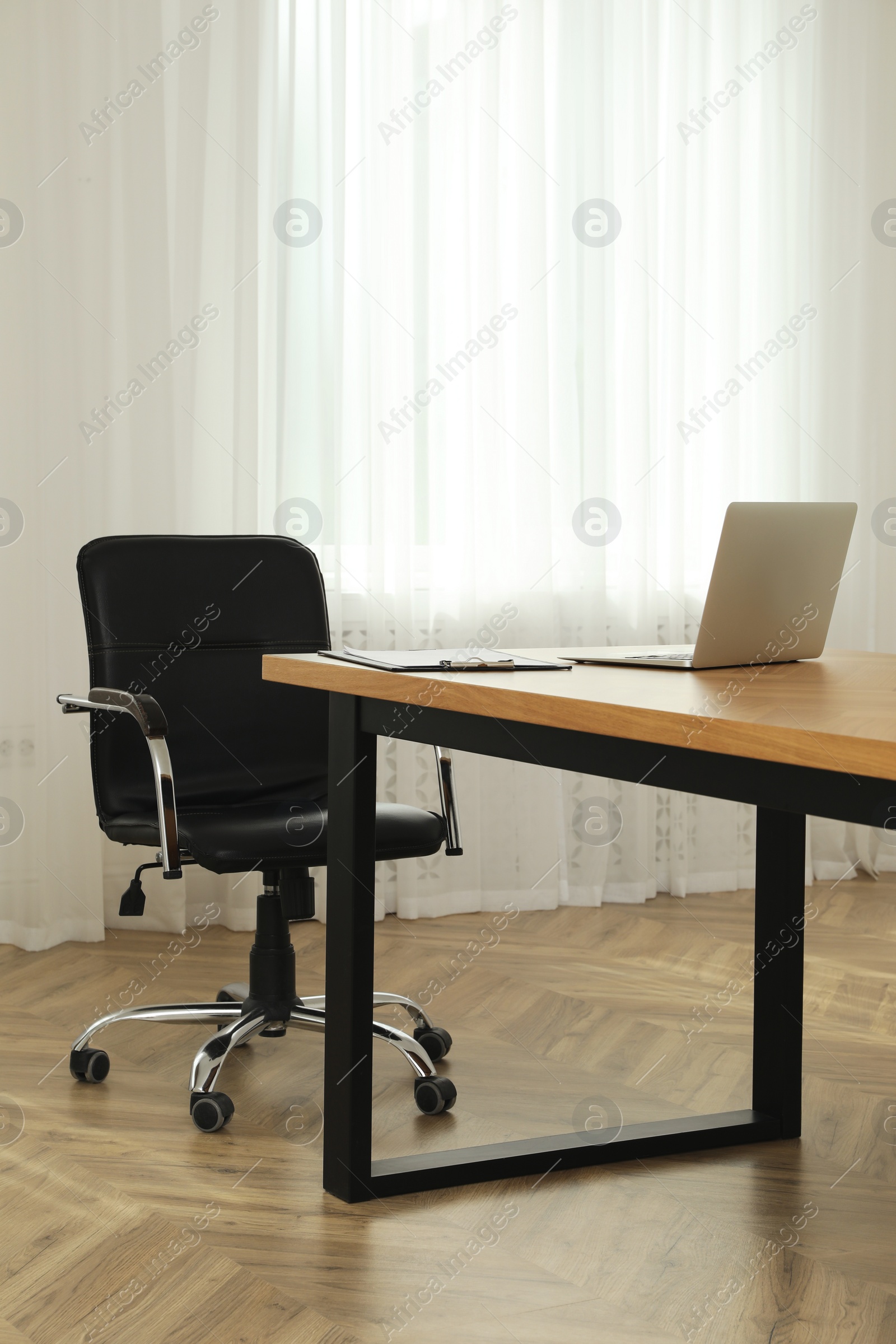 Photo of Director's office with large wooden table and comfortable armchair. Interior design