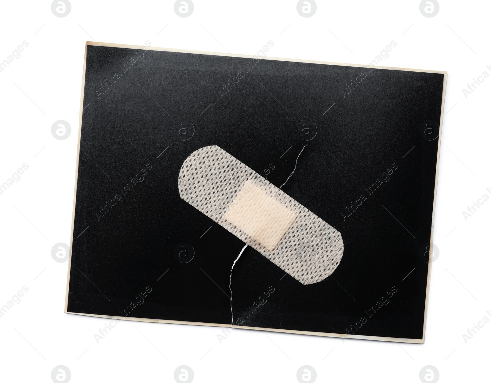 Photo of Black paper sheet with sticking plaster isolated on white, top view