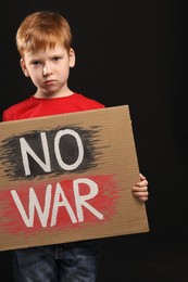 Photo of Boy holding poster No War against black background