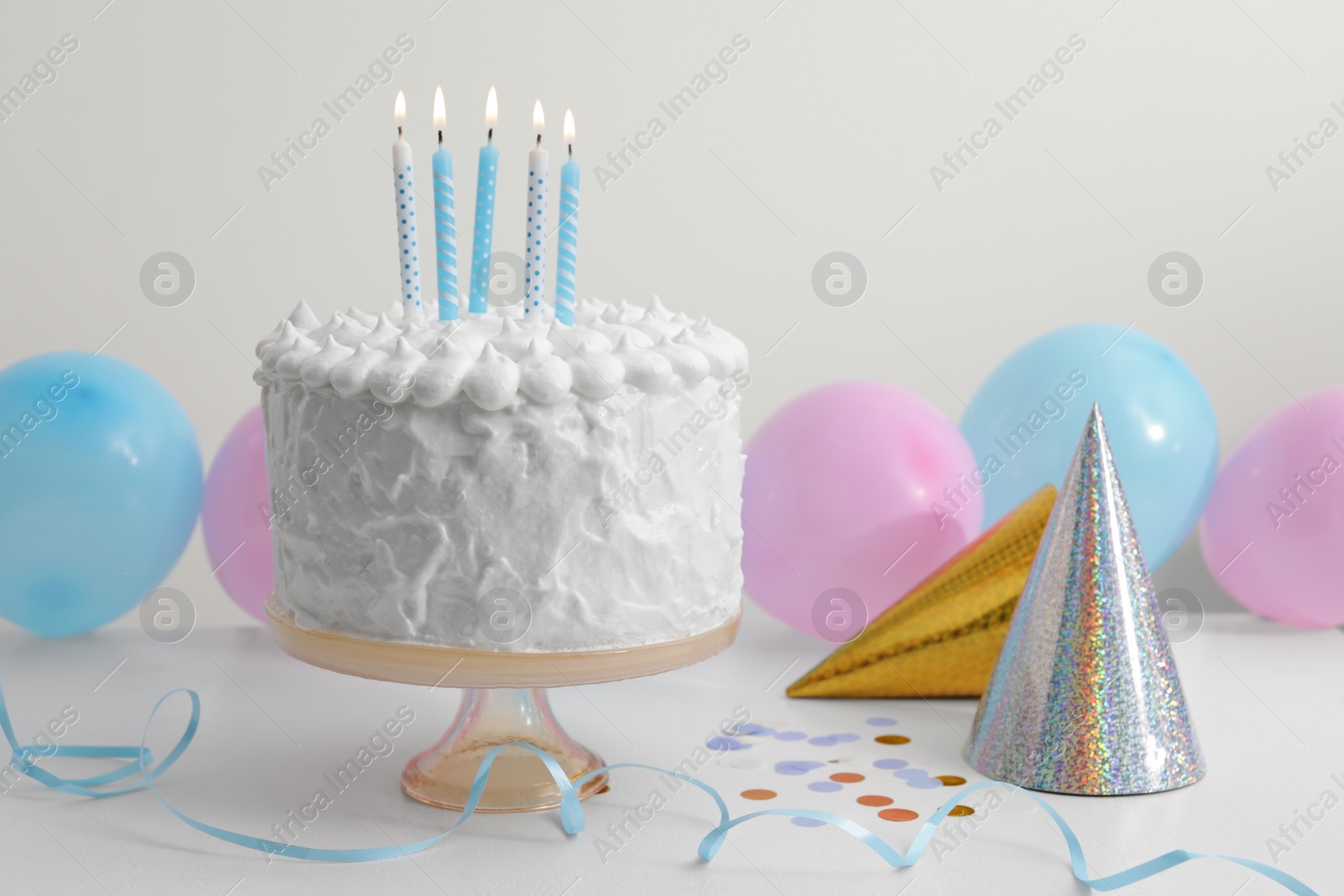 Photo of Delicious cake with burning candles and decorations on white table. Space for text