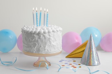 Photo of Delicious cake with burning candles and decorations on white table. Space for text