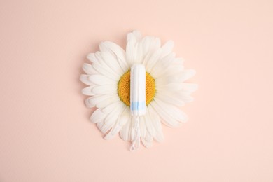 Photo of Tampon and chamomile on beige background, top view