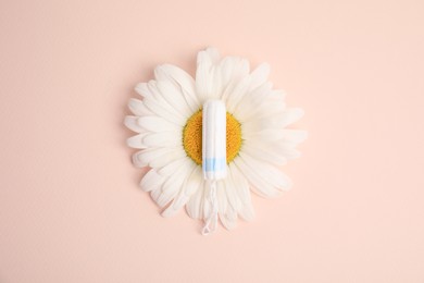 Tampon and chamomile on beige background, top view