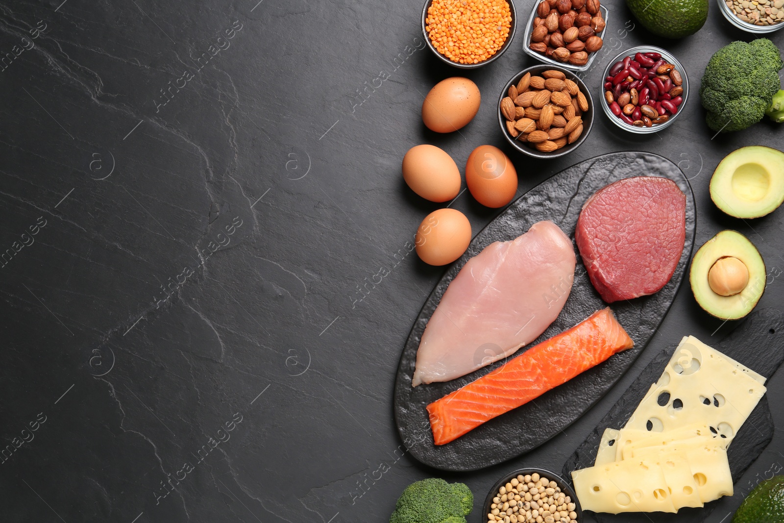 Photo of Different fresh products on black table, flat lay and space for text. Sources of essential amino acids