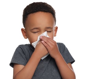 Photo of African-American boy blowing nose in tissue on white background. Cold symptoms