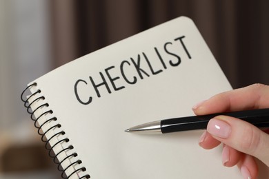 Woman filling Checklist with pen indoors, closeup