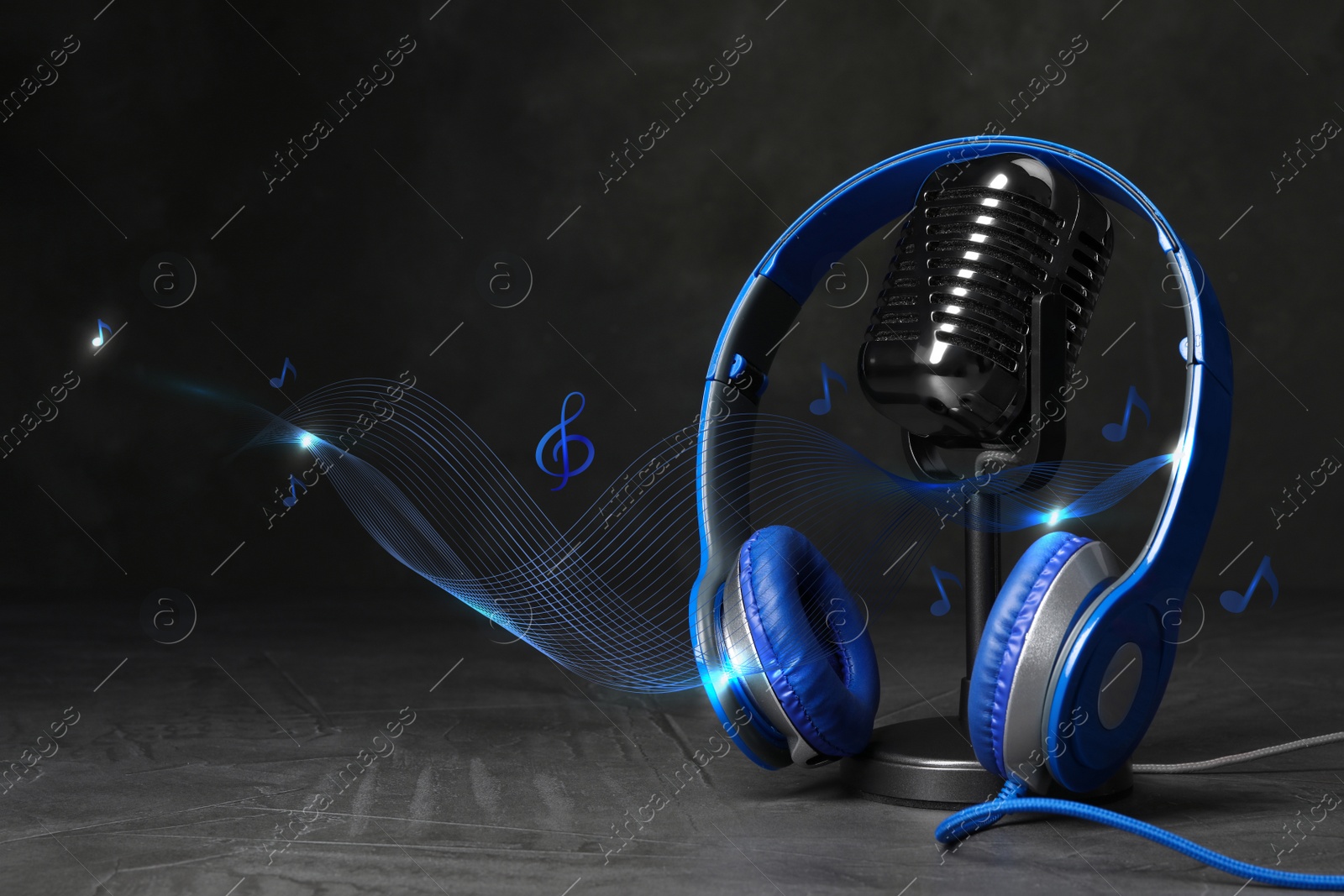 Image of Retro microphone and headphones with illustration musical notes on table against dark background. Space for text