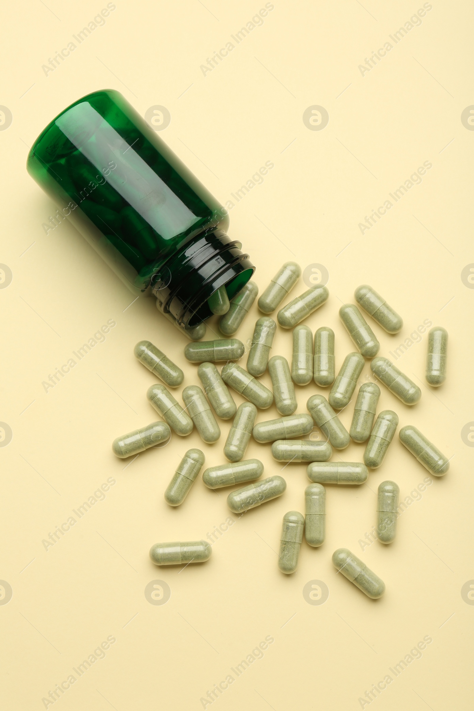 Photo of Vitamin pills and bottle on beige background, top view