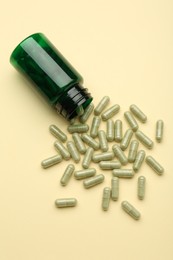 Photo of Vitamin pills and bottle on beige background, top view