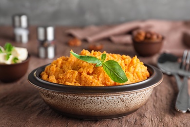 Bowl with mashed sweet potatoes on brown table