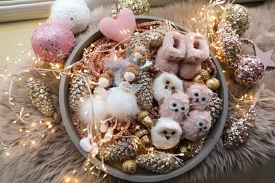 Photo of Beautiful Christmas tree baubles, toys and fairy lights on faux fur, flat lay