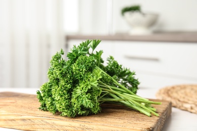 Photo of Board with fresh green parsley on table indoors