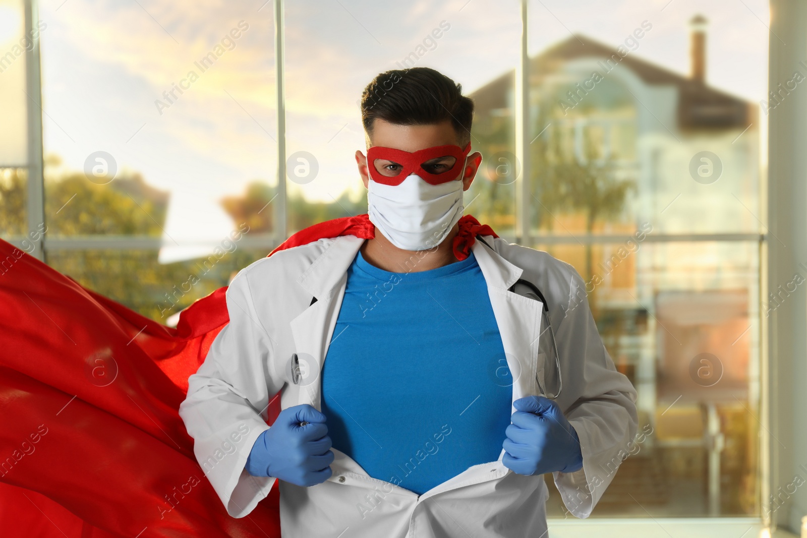 Photo of Doctor wearing face mask and cape indoors. Super hero power for medicine
