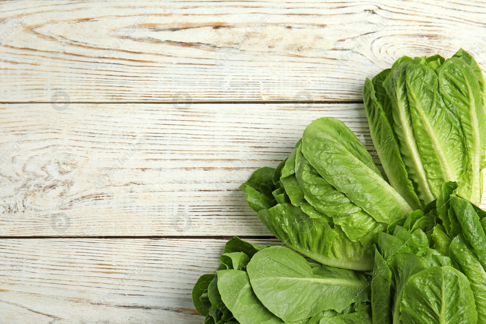 Photo of Fresh ripe cos lettuce on wooden background, top view