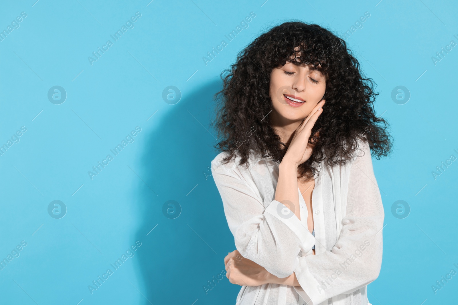 Photo of Portrait of beautiful young woman on light blue background, space for text