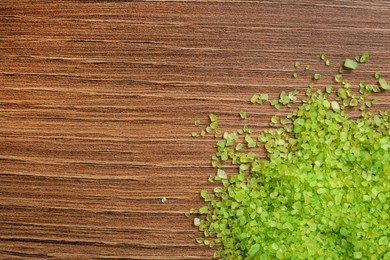 Aromatic sea salt on wooden table, top view. Space for text