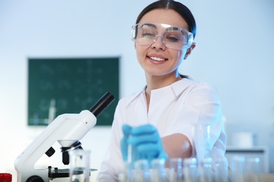 Photo of Female scientist working with sample in modern chemistry laboratory
