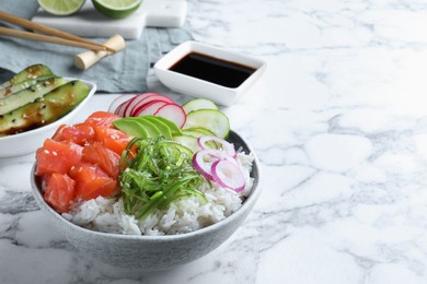 Photo of Delicious poke bowl with salmon and vegetables served on white marble table. Space for text