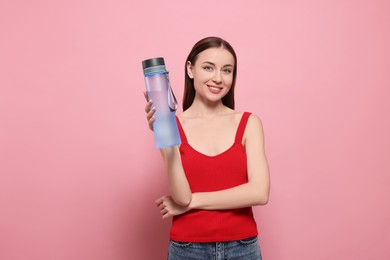 Photo of Beautiful young woman with transparent bottle for water on pink background