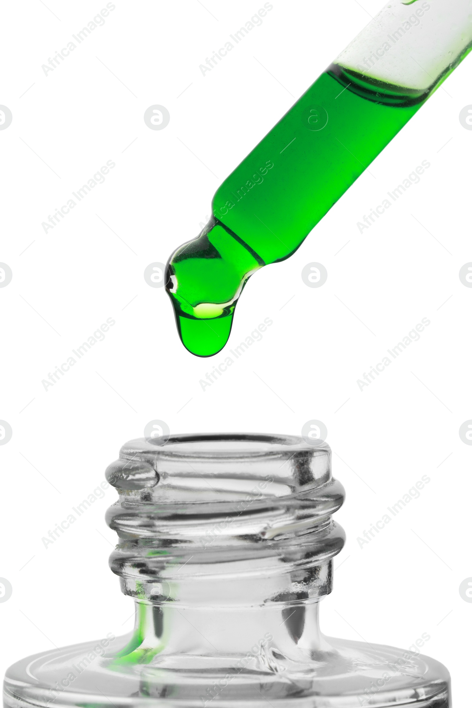 Photo of Dripping green facial serum from pipette into glass bottle on white background, closeup