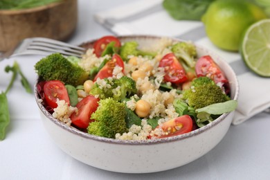 Photo of Healthy meal. Tasty salad with quinoa, chickpeas and vegetables served on white table, closeup