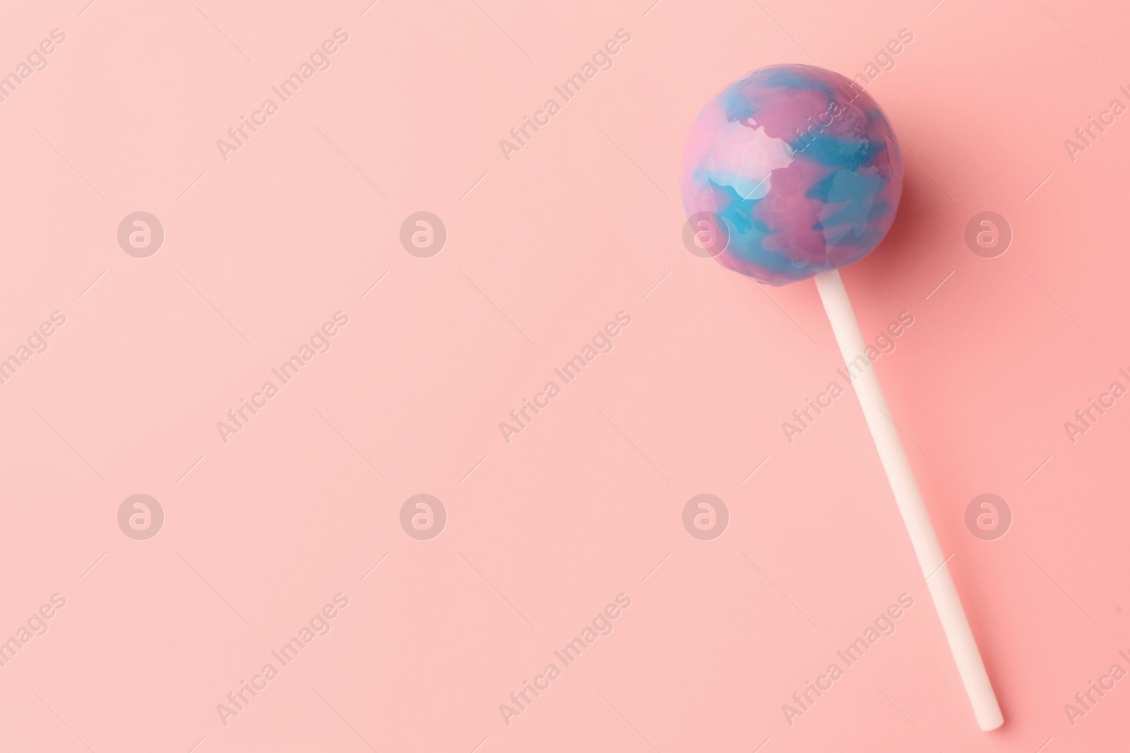 Photo of One tasty lollipop on pink background, top view. Space for text