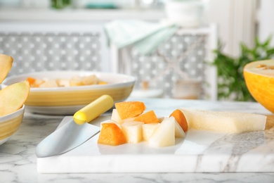 Photo of Sliced ripe melons on marble table in kitchen