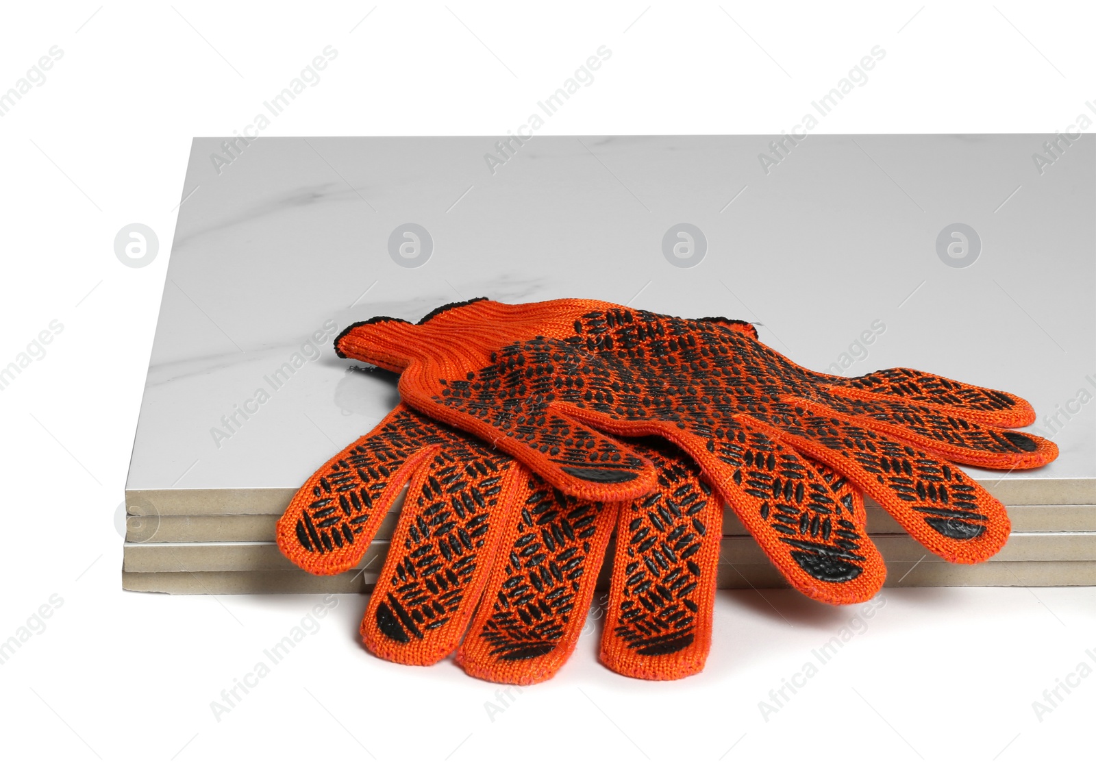 Photo of Stack of ceramic tiles and gloves on white background