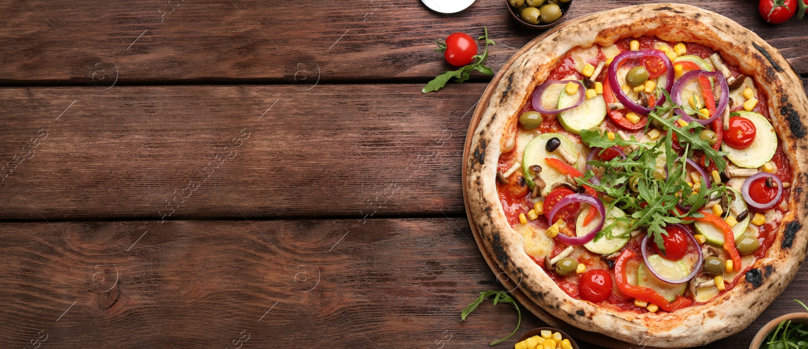 Image of Top view of hot delicious pizza on wooden table, space for text. Banner design 