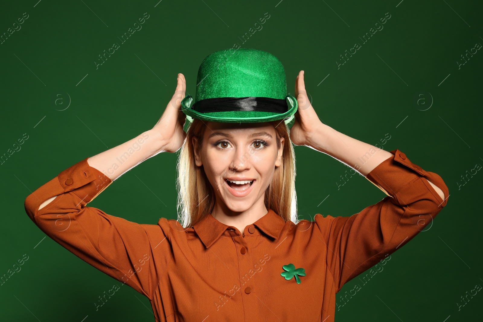 Photo of Young woman in green hat on color background. St. Patrick's Day celebration